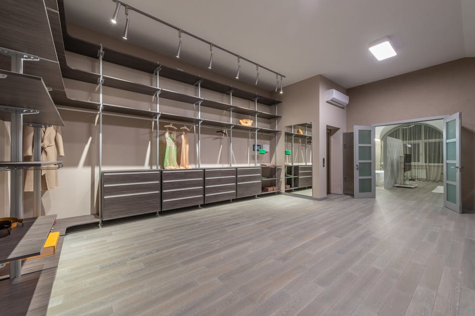 Explore this expansive, contemporary walk-in closet with elegant shelving and stylish lighting.